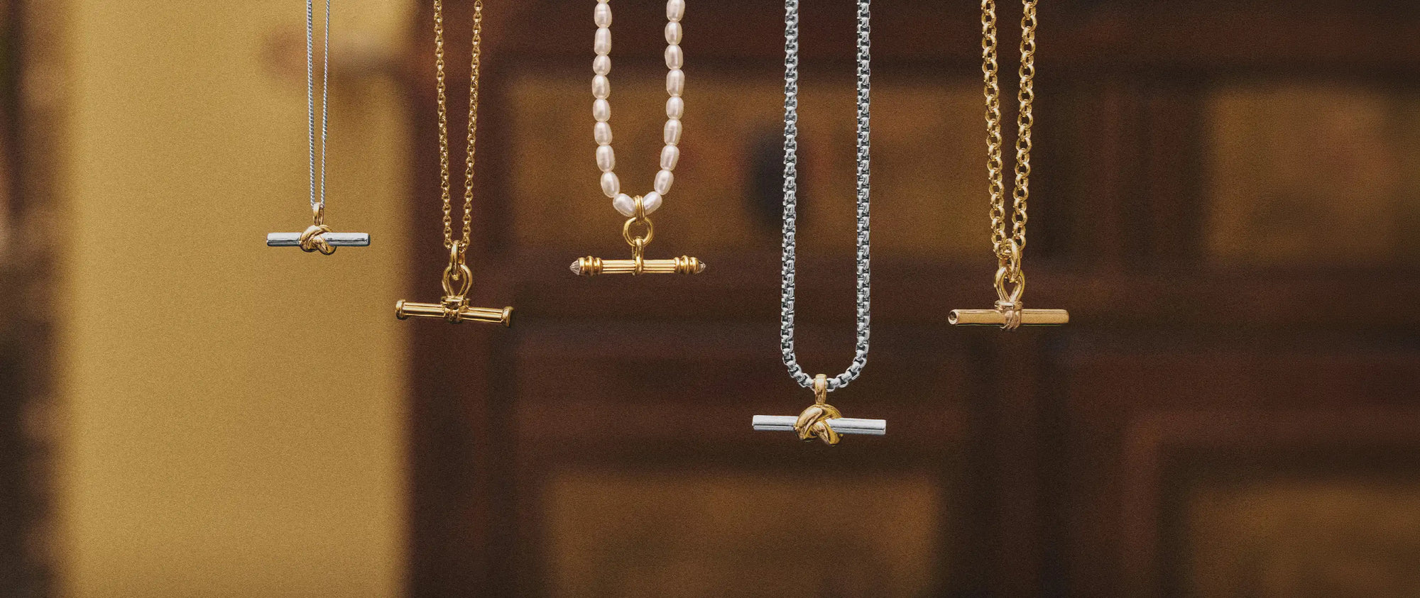 Gold and silver T Bar necklaces hanging
